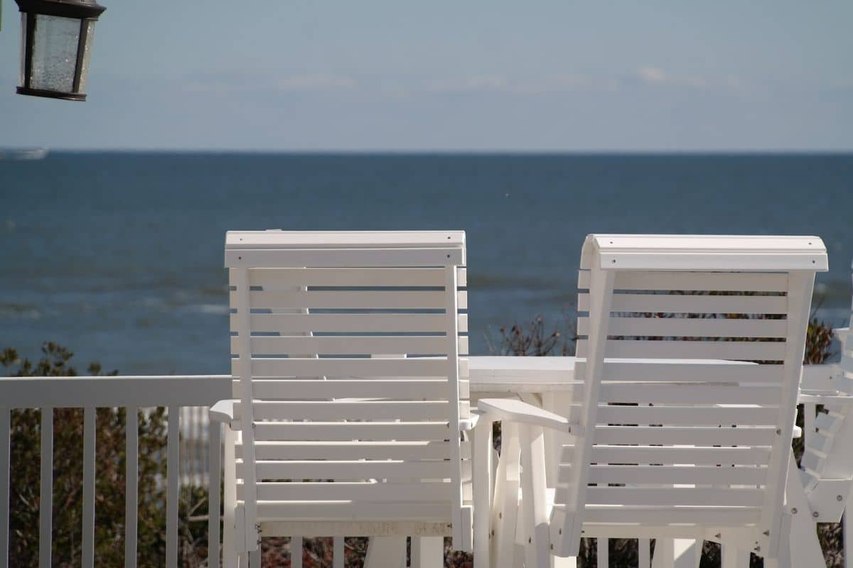 Zwei Liegestühle stehen auf einem Balkon mit Blick aufs Meer